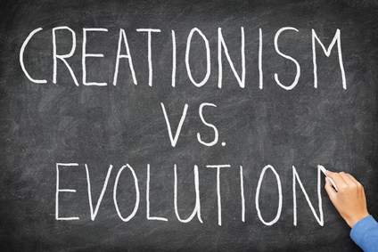 Creationism vs evolution. Religion and education concept. Hand writing on blackboard.